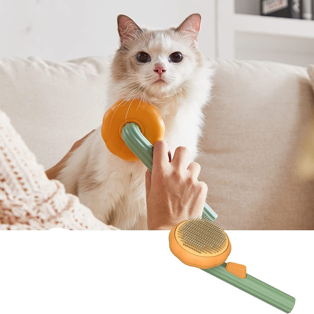 Cat being groomed with a pet brush featuring a pumpkin design, held by a person.